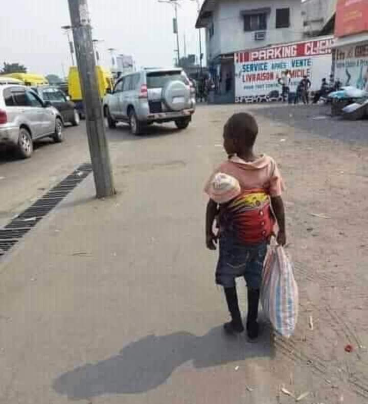 Nine years old Isaac, roaming around the street in search of daily for himself and his little brother, strapped in his back.