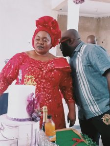 Bro. Obodo Augustine Ugochukwu whispering to Mummy Ijeoma Chioma during cake cutting.
