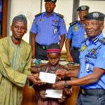 IGP Kayode Adeolu Egbetokun presenting cheques to the next of kins of deceased officers.