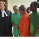Emmanuel Acha (2L), dressed in prison gown with his lawyer and another human rights defender, Okechukwu Nwanguma (2R) and a fellow inmate.