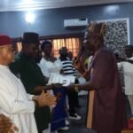 The national chairman, ost Communities of Nigeria (producing oil and gas) (HOSCON), Prince Dr. Mike Emu, presenting a certificate to the Abia State chairman, Hon. Philip Agomuo at the inauguration ceremony.