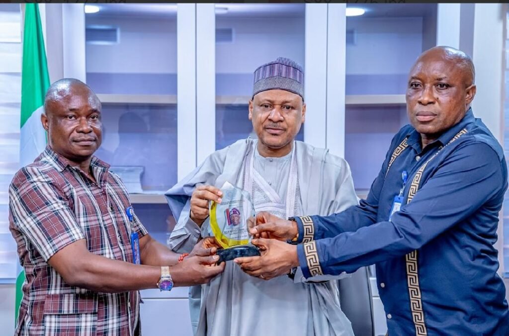 Comrd. Akpovoke Otiti (1L) presenting and award of excellence to the hon. Minister of Information and National Orientation, His Excellency Idris Mohammed, (M) and Prince Clinton Uba. 
